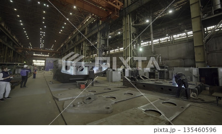 Shipbuilders welding metal parts in a shipyard. Stock clip Shipbuilders welding metal parts in a shipyard. Stock clip 135460596