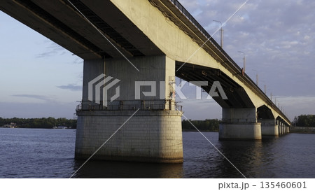 Bridge over wide river under cloudy sky at sunset. Clip 135460601