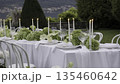 Elegant white table setting with candles and flowers in garden. Action 135460642