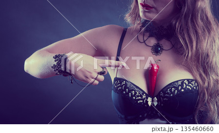 Woman wearing sexy lingerie holding chilli on chest Woman wearing sexy lingerie holding chilli on chest 135460660