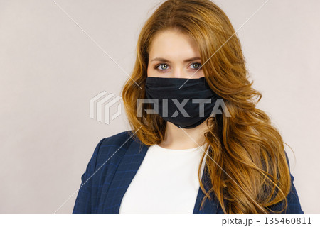 Woman using protective face mask. Woman using protective face mask. 135460811