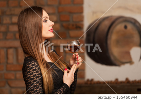 Woman tasting wine in rural cottage interior Woman tasting wine in rural cottage interior 135460944