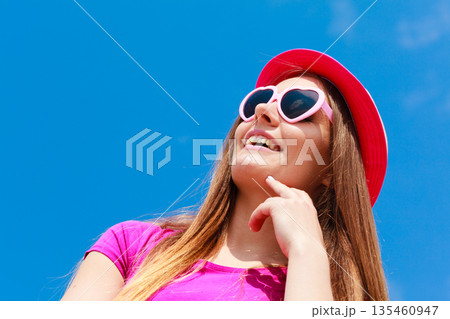 Woman wearing heart shaped sunglasses and hat Woman wearing heart shaped sunglasses and hat 135460947