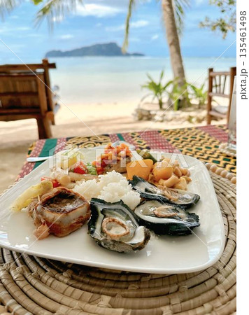 Gourmet seafood platter with oysters and rice served on a tropical beach resort Gourmet seafood platter with oysters and rice served on a tropical beach resort 135461498