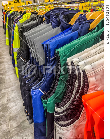 rack of colorful, durable workwear and high-visibility safety vests hanging in retail store, available in various sizes for professionalsProfessional Work and Safety Vests for Sale. High quality photo 135462208
