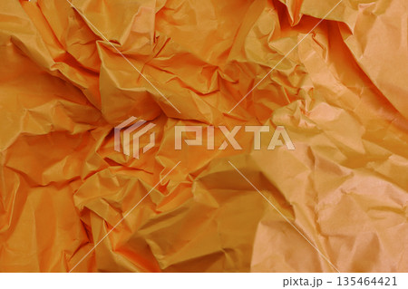 Close-up full frame texture of vibrant orange crumpled and wrinkled paper. Perfect for creative backgrounds, design projects, and abstract patterns with dynamic shadows and highlights Close-up full frame texture of vibrant orange crumpled and wrinkled paper. Perfect for creative backgrounds, design projects, and abstract patterns with dynamic shadows and highlights 135464421