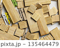 Top-down view of scattered wooden blocks in various sizes and shapes mixed with small colorful and natural wood clothespins. Ideal for craft, hobby, and DIY project concepts 135464479