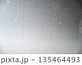 A close-up view of a gray painted surface featuring vertical liquid streaks and drips, creating a grunge industrial background for design projects 135464493