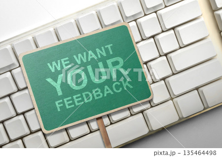 A green chalkboard sign with the text We Want Your Feedback resting on a white vintage-style computer keyboard, representing customer surveys, reviews, and online user feedback A green chalkboard sign with the text We Want Your Feedback resting on a white vintage-style computer keyboard, representing customer surveys, reviews, and online user feedback 135464498