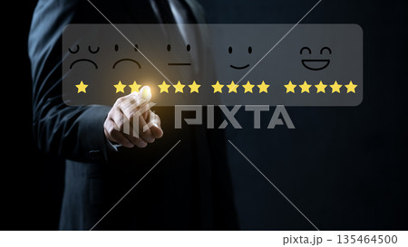 Professional businessman interacting with a digital interface for customer feedback. Virtual display showing star icons and facial expressions to evaluate service satisfaction and quality 135464500