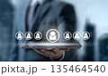 Businessman holding a tablet with digital people icons, symbolizing HR management, recruitment, and talent selection in a modern corporate environment 135464540