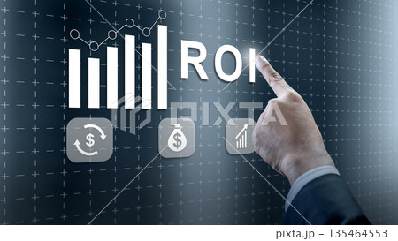 A businessman points to ROI on a futuristic digital screen featuring financial icons and charts representing business growth and investment success A businessman points to ROI on a futuristic digital screen featuring financial icons and charts representing business growth and investment success 135464553