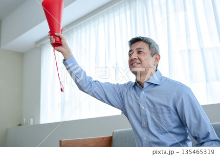 テレビ観戦で応援するシニア男性 135465319
