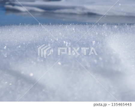太陽光に融け始める雪と氷湖（20260110091207） 135465443