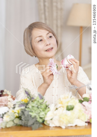 リビングで趣味のフラワーアレンジメントをするシニア女性 リビングで趣味のフラワーアレンジメントをするシニア女性 135466909