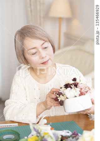 リビングで趣味のフラワーアレンジメントをするシニア女性 135466929