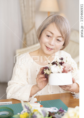 リビングで趣味のフラワーアレンジメントをするシニア女性 135466931