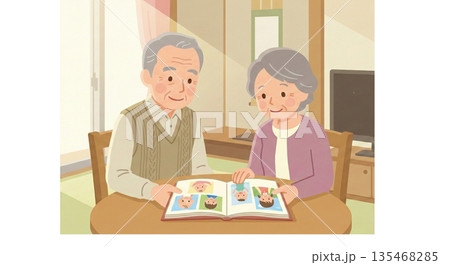 孫の写真を見て微笑む夫婦 135468285