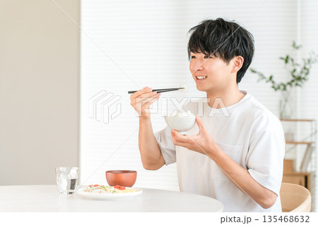 食卓でお米,白米を食べる若いアジア人男性 135468632