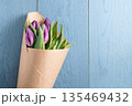 top view of purple tulips on blue wood background 135469432
