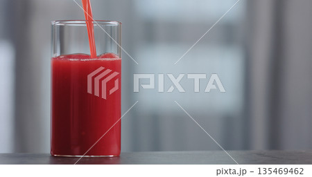 pour red orange juice into glass on concrete countertop with copy space pour red orange juice into glass on concrete countertop with copy space 135469462