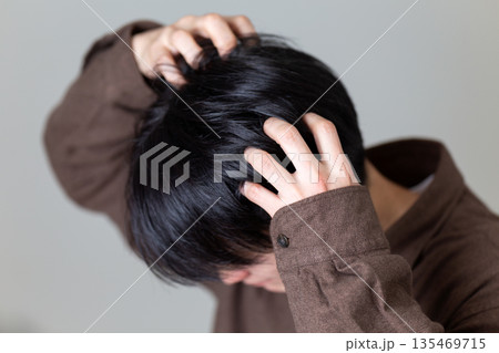 頭皮の痒みに苦しむミドル男性 135469715