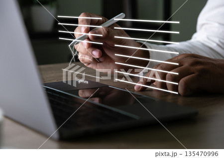 Electronic signature concept, businessman signs document on a laptop, secure e signing, document contract approval, identity verification Electronic signature concept, businessman signs document on a laptop, secure e signing, document contract approval, identity verification 135470996