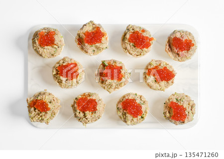 Delicious tuna tartlets topped with vibrant caviar on a clean white platter Delicious tuna tartlets topped with vibrant caviar on a clean white platter 135471260