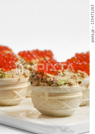 Delicious tuna tartlets topped with bright red caviar served at a stylish gathering Delicious tuna tartlets topped with bright red caviar served at a stylish gathering 135471263