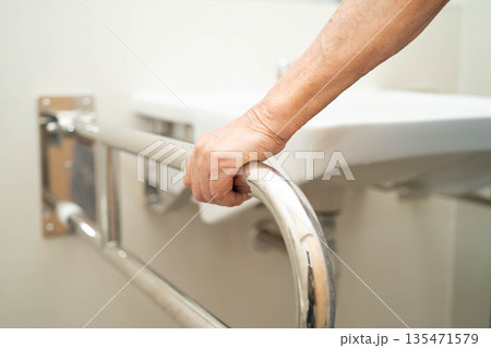 Asian elderly woman use safety handrail in bathroom. 135471579
