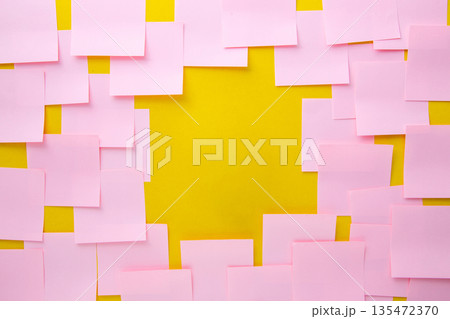 Pink sticky notes forming frame on yellow background Pink sticky notes forming frame on yellow background 135472370