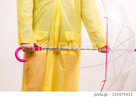 Woman wearing waterproof coat holding umbrella 135475415