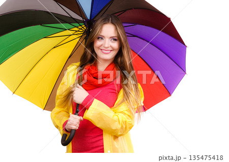 Woman in rainproof coat under umbrella 135475418