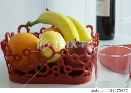 fruit bowl centerpiece with wine on modern kitchen table 135475477