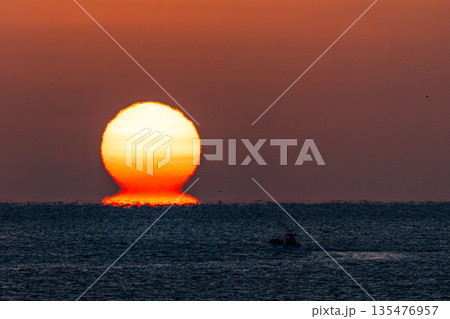 海から浮かぶ朝日 135476957