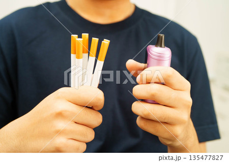 Man holding electronic cigarettes, no smoking. 135477827