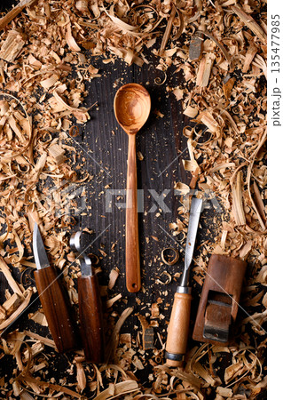 Handcrafted wooden spoon with heap of wooden filings Handcrafted wooden spoon with heap of wooden filings 135477985