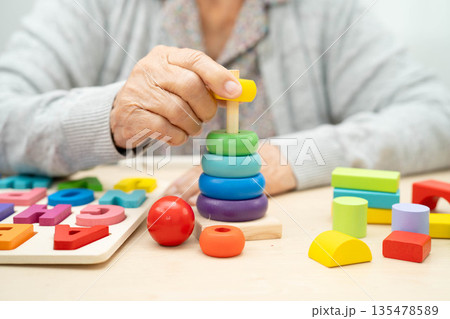 Asian elderly woman playing game. 135478589