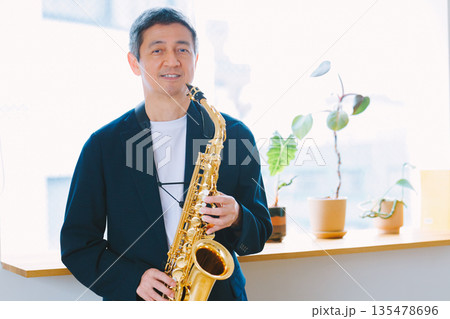 自宅でサックスを演奏する男性 135478696