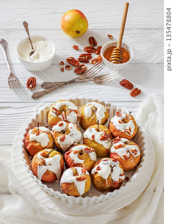 Tasty Baked Apples with Pecans and Cream 135478804