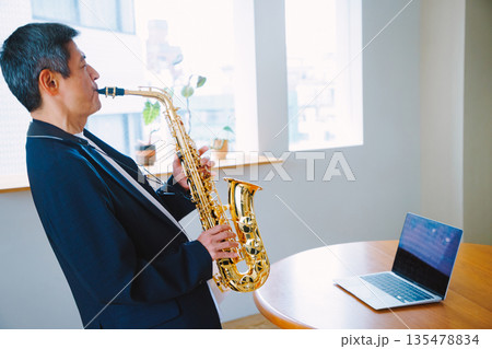自宅でサックスを演奏する男性 135478834