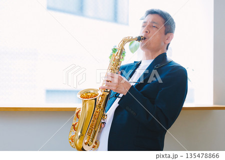 自宅でサックスを演奏する男性 135478866