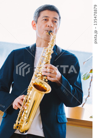 自宅でサックスを演奏する男性 自宅でサックスを演奏する男性 135478879