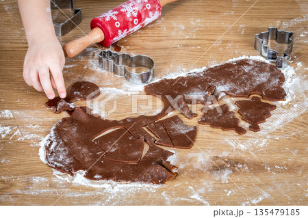 Child Making Holiday Cookies With Gingerbread Dough And Festive Cutout Shapes 135479185