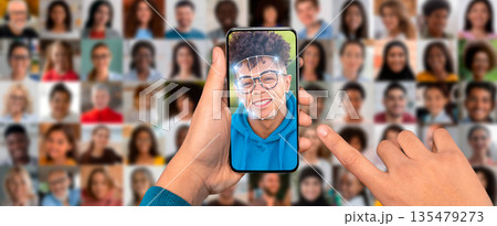 A person is engaging with a smartphone displaying a face scanning feature. 135479273