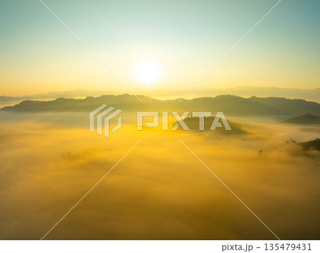 Aerial view of flowing fog waves on mountain tropical rainforest,Bird eye view image over the clouds Amazing nature background with clouds and mountain peaks in Thailand Aerial view of flowing fog waves on mountain tropical rainforest,Bird eye view image over the clouds Amazing nature background with clouds and mountain peaks in Thailand 135479431