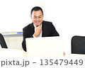 ノートPCを見る笑顔のスーツ姿の中年男性 135479449