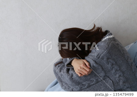 落ち込んでうつむく女性の後ろ姿　悩みやストレスを抱えるイメージ 135479499