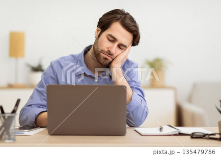 Tired Businessman Sleeping At Laptop Computer Sitting At Desk At Workplace In Modern Office. Insomnia And Fatigue Problem, Boring Job Concept. Selective Focus Tired Businessman Sleeping At Laptop Computer Sitting At Desk At Workplace In Modern Office. Insomnia And Fatigue Problem, Boring Job Concept. Selective Focus 135479786