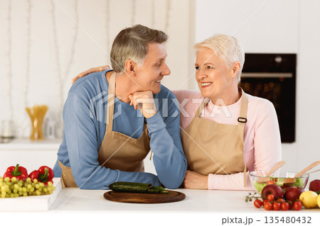 Elderly Spouses Preparing Dinner In Modern Kitchen, Embracing Standing Near Table Cutting Vegetables For Salad At Home. Happy Senior Couple Posing Cooking Food Together Indoor. Nutrition And Recipes Elderly Spouses Preparing Dinner In Modern Kitchen, Embracing Standing Near Table Cutting Vegetables For Salad At Home. Happy Senior Couple Posing Cooking Food Together Indoor. Nutrition And Recipes 135480432